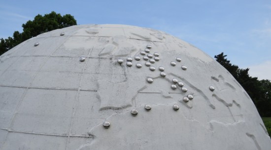 Closeup of large all-white globe. The European side has metal discs marking locations where Illinoisans died in combat.