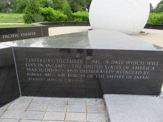 Short black marble wall engraved with FDR's famous speech after Pearl Harbor: "Yesterday, December 7, 1941, a date which will live in infamy - the United States of America was suddenly and deliberately attacked by naval and air forces of the empire of Japan."