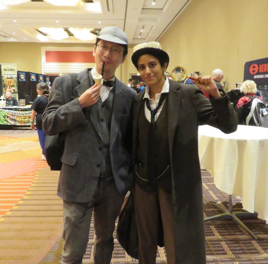 Holmes and Watson cosplayers, with pipe and magnifying glass.