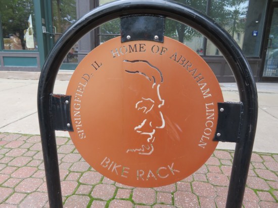 Circular metal sign reading "Springfield IL Home of Abraham Lincoln Bike Rack".