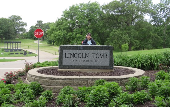 Anne posing behind a stone rectangular sign for