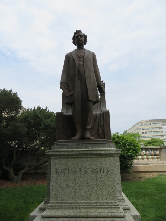 Statue of Richard Yates standing in front of a nice chair.