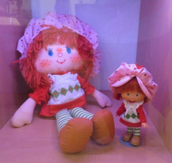 Two Strawberry Shortcake dolls in a vitrine.