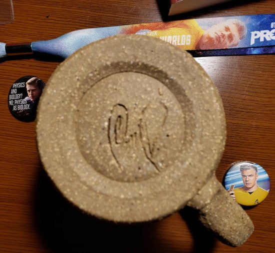 Anson Mount autograph etched into the underside of a beige mug.