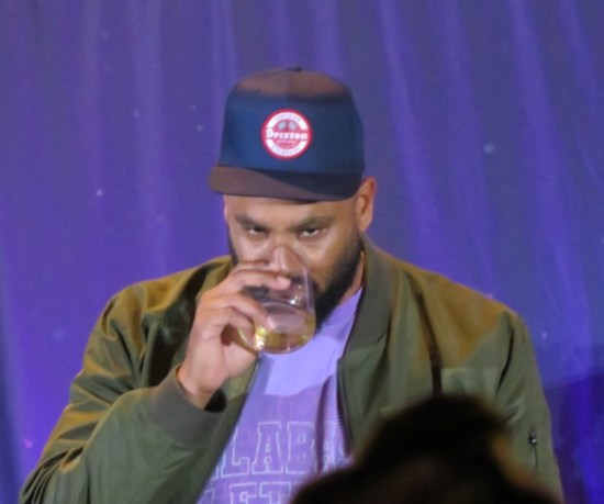 Cirroc Lofton drinking, with Brixton ball cap.