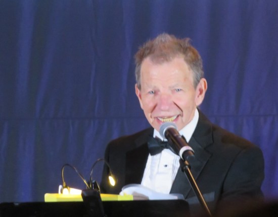 Max Grodenchik singing in front of a music stand, wearing a tux.