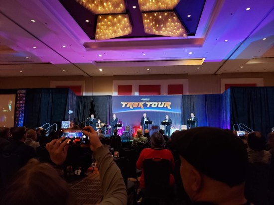 Our view of the Rat Pack concert from the ninth row without zooming. Five guys in tuxes onstage with a "TREK TOUR" logo on top of the back wall.