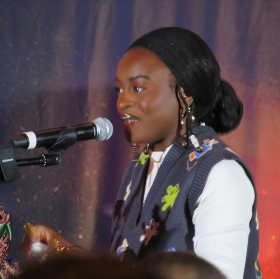 Celia Rose Gooding in white shirt and grey vest.