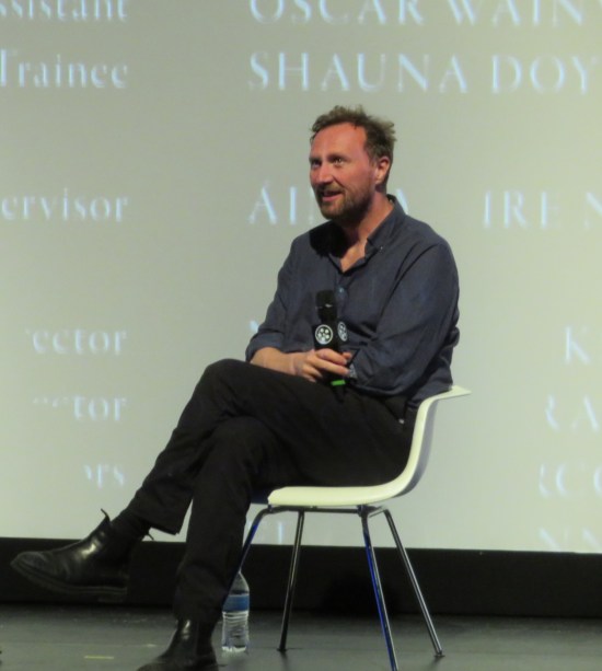 Tim Mielants sitting on stage while the end credits roll behind him.