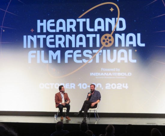 Interview on stage with the Heartland logo on the screen behind them.