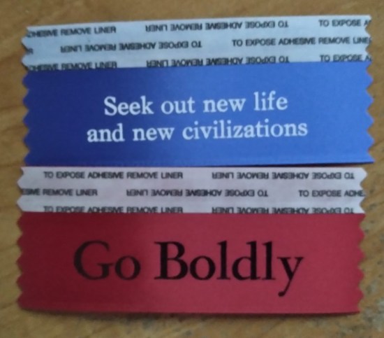 A blue ribbon that says "Seek out new life and civilizations" and a red ribbon that says "Go Boldly".