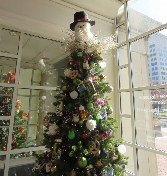 Christmas tree decorated with a white owl wearing a Frosty the Snowman hat. plus beers and pretzels.