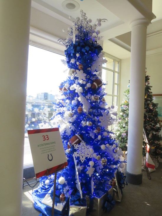 Blue Christmas tree with footballs and large white snowflakes.