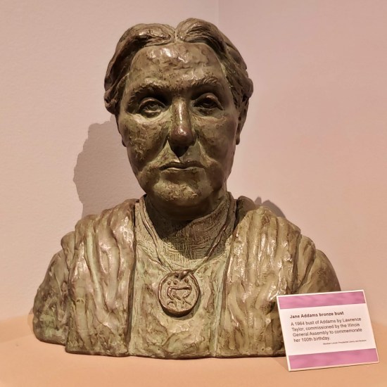 Bust sculpted of an older woman, set in a display corner.