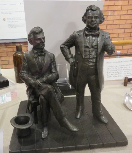 Tiny gray statues of Lincoln and Douglas.