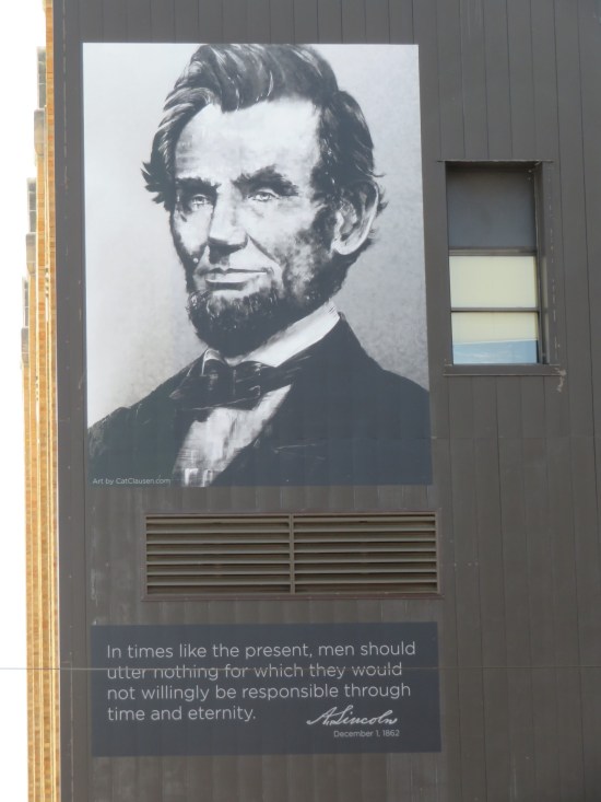 Giant Lincoln photo on the side of a multi-story building with a quote: "In times like the present, men should utter nothing for which they would not willingly be responsible through time and eternity."
