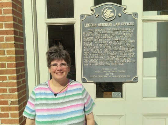 Lincoln-Herndon Law Offices plaque on the side of the building. Anne poses next to it.