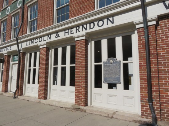 Side of the Lincoln & Herndon Law Office, white-trimmed thin vertical windows and red brick walls.