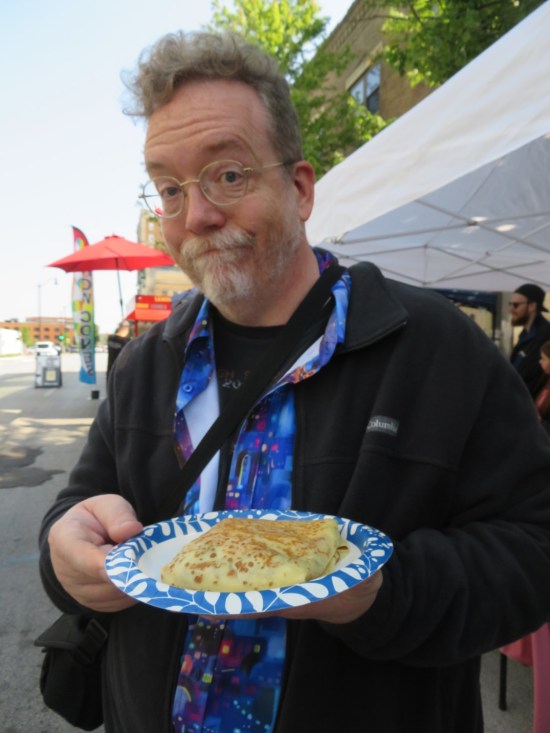 me holding a paper plate with a crepe on it, toppings tucked inside and not appearing.
