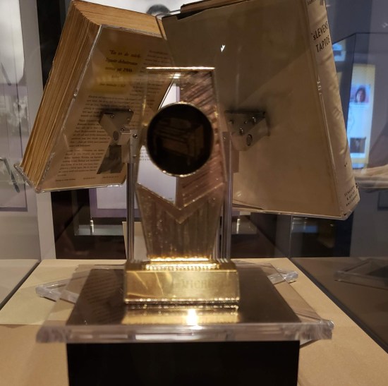 Glass trophy with a medallion in the middle of it.