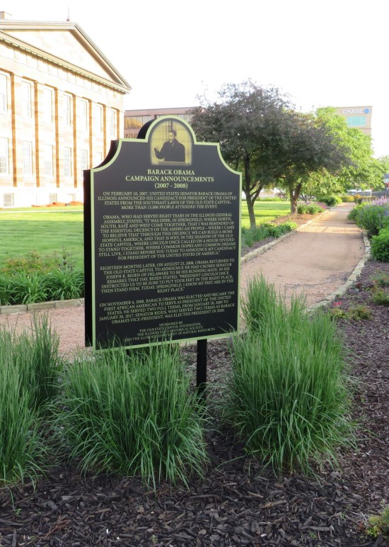 Large historical marker in tall grass on a street corner. Titled "Barack Obama Campaign Announcements 2007-2008". Hundreds of words follow.