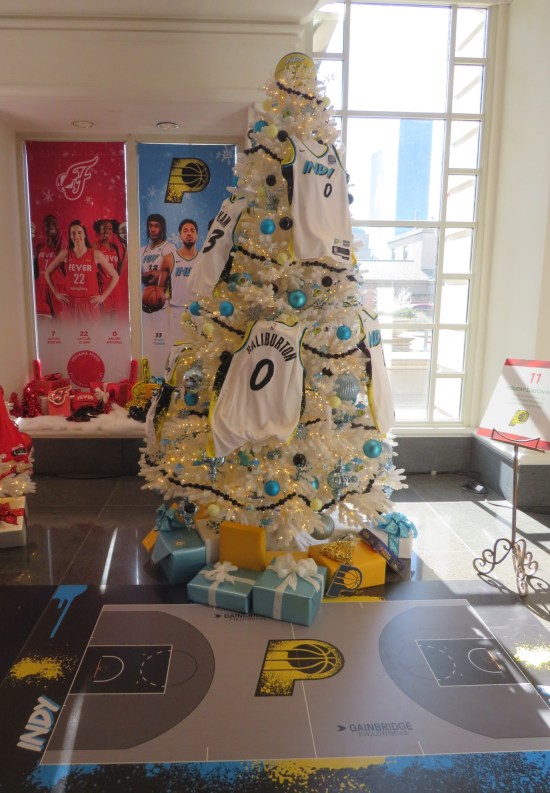 White Xmas tree with blue and black ornaments, and basketball jerseys.