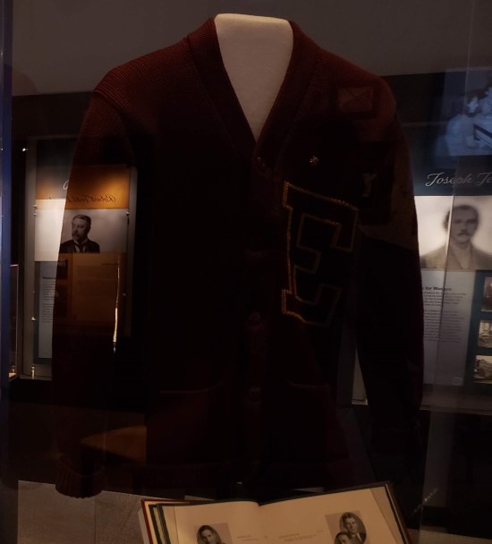 Dark red letterman sweater with an R on the chest.