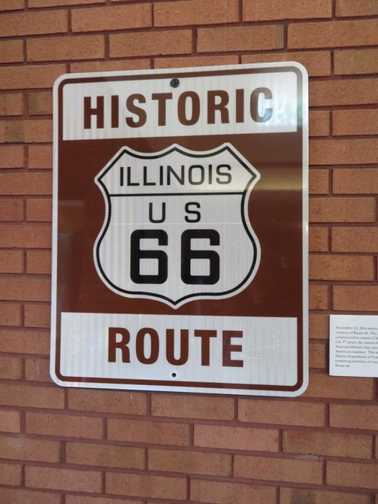 Sign hung on an interior brick wall: "Historic Illinois U.S. Route 66".