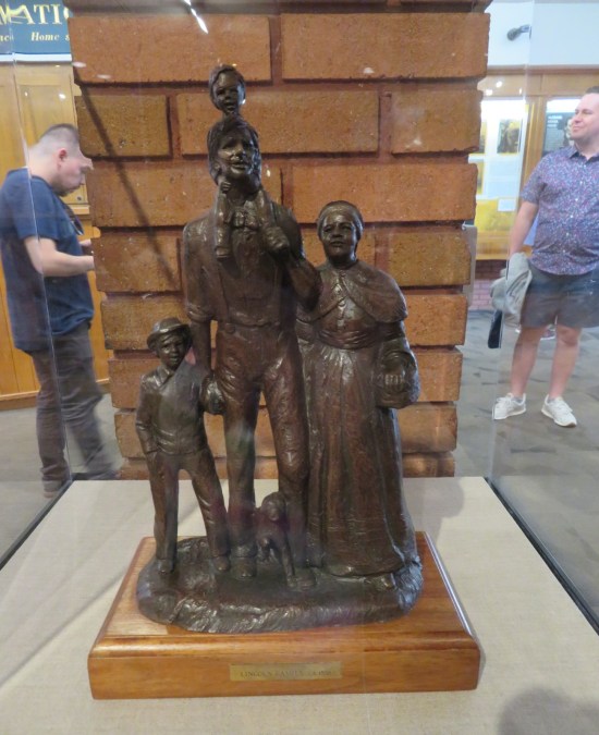 Tiny brown statues of the Lincoln family in a vitrine.