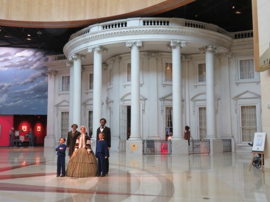 White House replica inside an even bigger building. Statues of the five Lincoln family members stand in front.