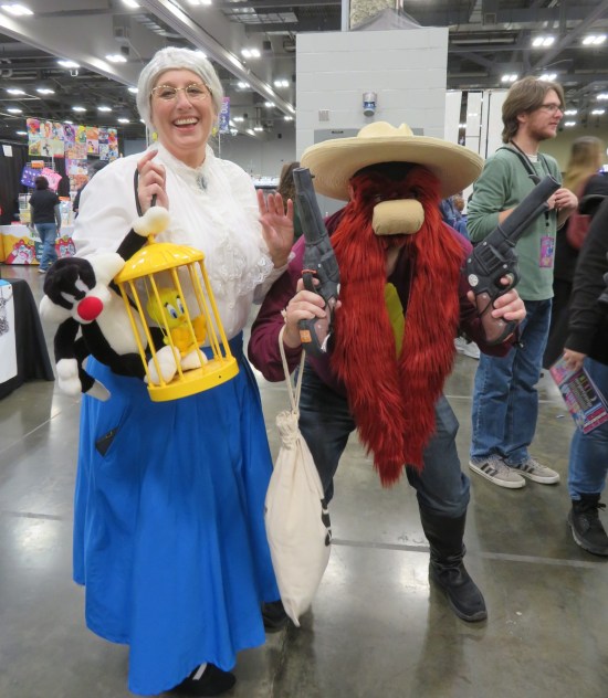 cosplay: Granny with stuffed Tweety and Sylvester dolls, and Yosemite Sam with a pair of cartoon revolvers.