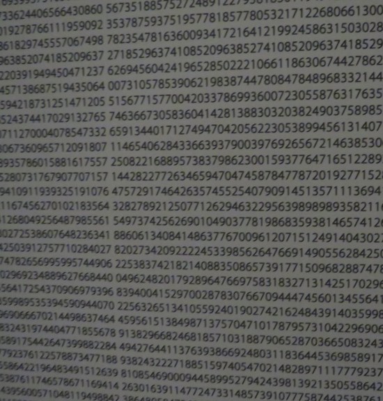 Closeup of white blinds with nothing on them but rows of black typeset numbers.