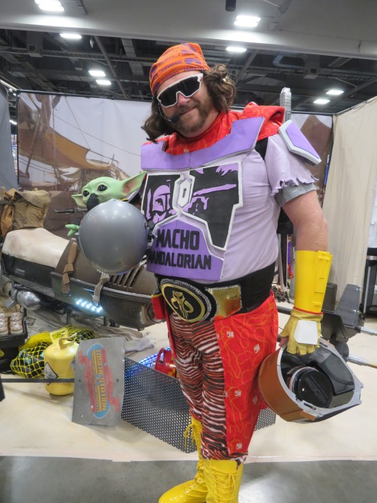 costume: Macho Man Randy Savage mash-up with Star Wars, holding Grogu in a gray ball.