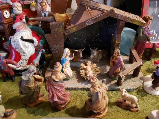 Nativity scene on a green tablecloth with "A Christmas Story" action figures on either side.