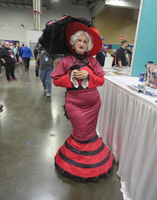costume: red and black dress with matching hat and parasol.