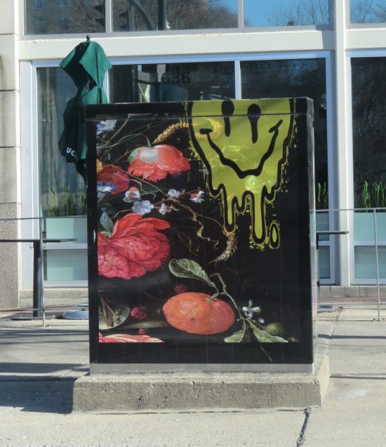 Electrical box painted black with unusual flowers and a big melting smiley face.