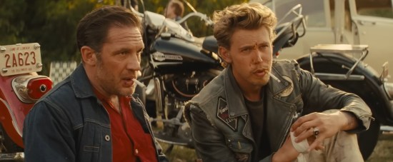 Two white guys in denim jackets, sitting around smoking.