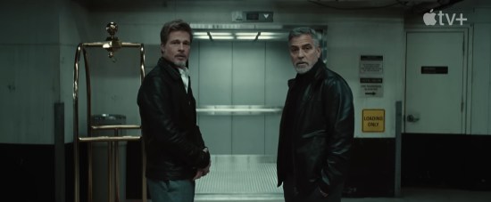 Brad Pitt and George Clooney in an underground garage, staring agape at an offscreen surprise.