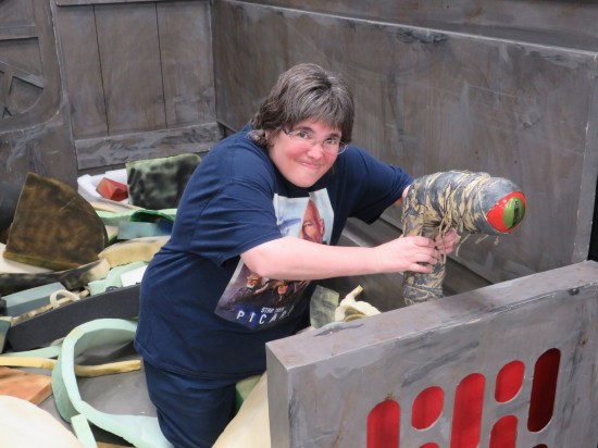 Anne with her hands around a dianoga sculpture in the corner of a fake trash compactor.,