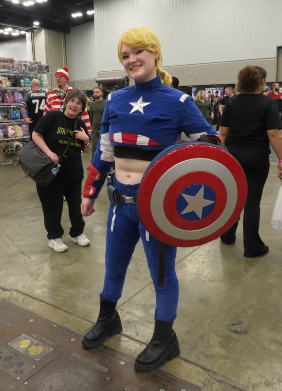 cosplay: female Captain America cosplayer in front, my own wife in mid-ground, Where's Waldo cosplayer in the way back.