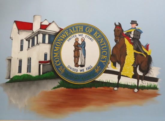 Commonwealth of Kentucky seal painted on a wall, next to a horsewoman and a two-story house.
