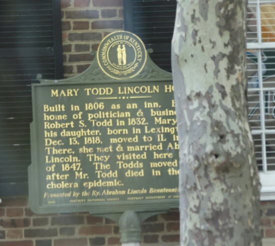 Historical marker outside the Mary Todd Lincoln House, partially obscured by a tree.