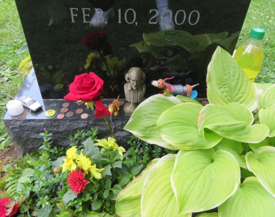 On the foot of Varney's tombstone are two Slinky Dog toys, a rose, a Mello Yello bottlecap, a tiny Shakespeare bust, several pennies, a 21-ounce bottle of yellow soda and possibly a toy DeLorean.