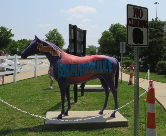 Purple horse statue with large blue Shelbyville logo on one side, touting "the Gateway to Bluegrass".