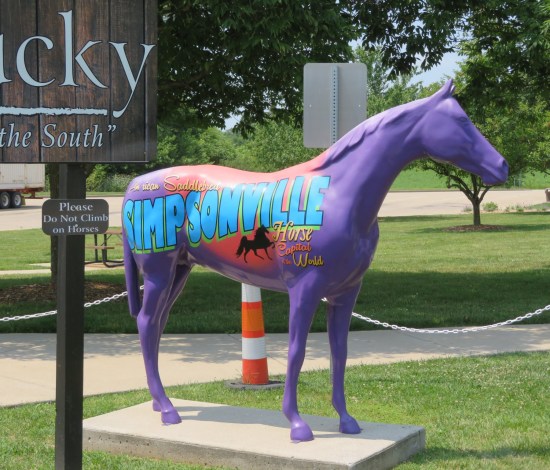 Purple horse statue with large blue logo on one side for the town of Simpsonville, "Horse Capital of the World".