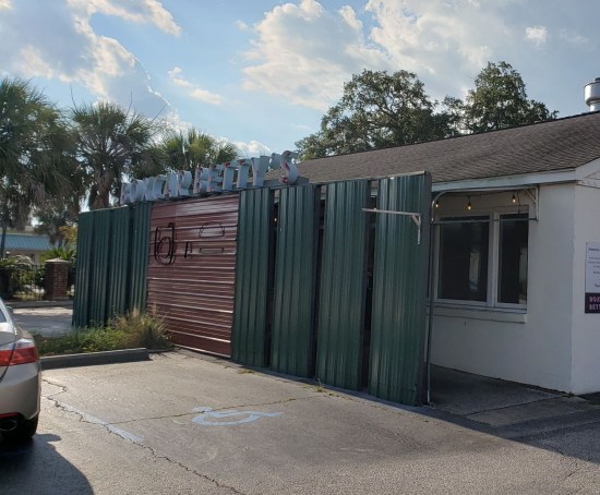 restaurant with metal corrugated wall blocking views of the front door.