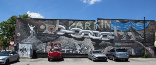 large mural of some kind of parking sign with heavy-duty chains sealing its doors?