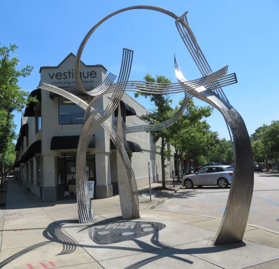 17-foot-tall metal sculpture shaped like several musical staves upright and waving at each other like palm trees in a strong wind.