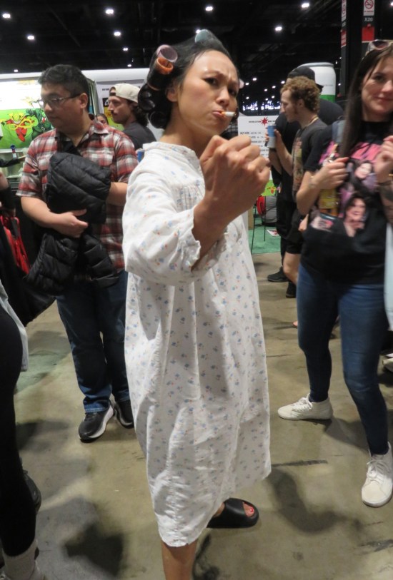 Cosplayer as angry lady in frumpy nightgown and hair rollers, cigarette dangling from mouth, ready to punch you into the stratosphere.
