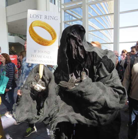 Nazgul cosplayer with sign picturing The One Ring and asking "Lost ring, if found please call 1-800-4NAZGUL".